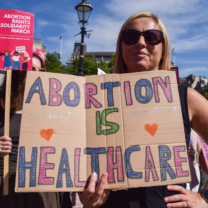 Protester holding a "Abortion is Healthcare" sign. Reproductive justice advocates warn there will be...