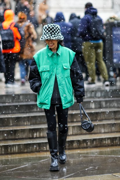 NEW YORK, NEW YORK - FEBRUARY 13: A guest wears a black and white checkered print pattern fluffy ove...