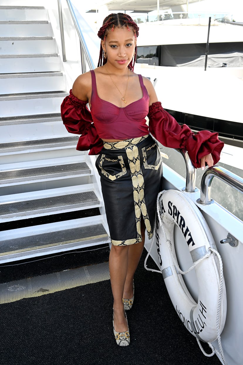 Amandla Stenberg wearing a corset top with detached sleeves and a leather skirt with snakeskin detai...