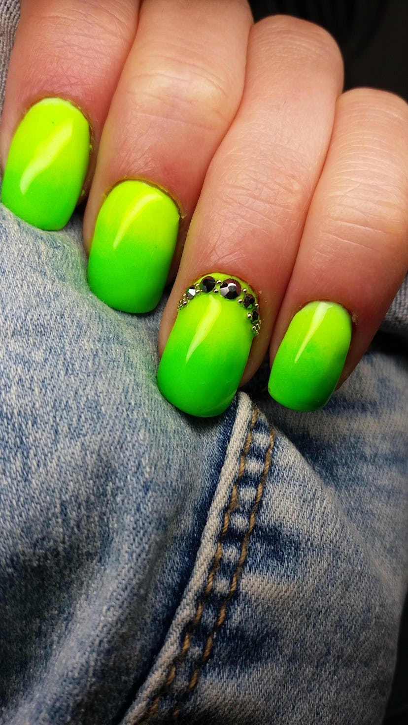 A closeup of green neon bright summer nails.