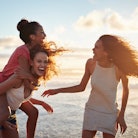Young women hanging out at the beach, at sunset use ocean puns for Instagram captions.