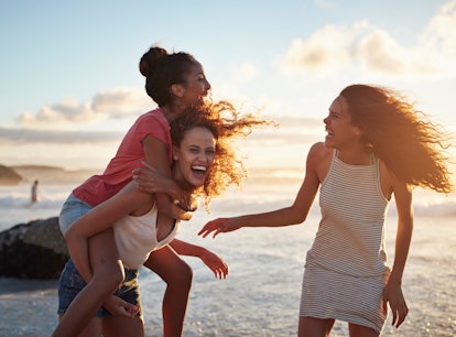 Young women hanging out at the beach, at sunset use ocean puns for Instagram captions.