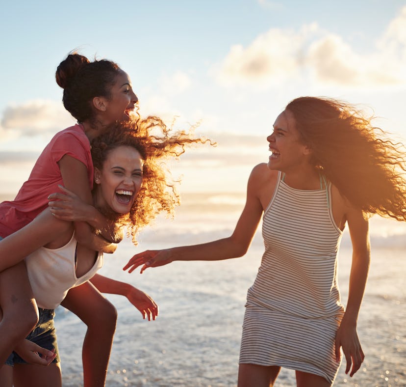 Young women hanging out at the beach, at sunset use ocean puns for Instagram captions.