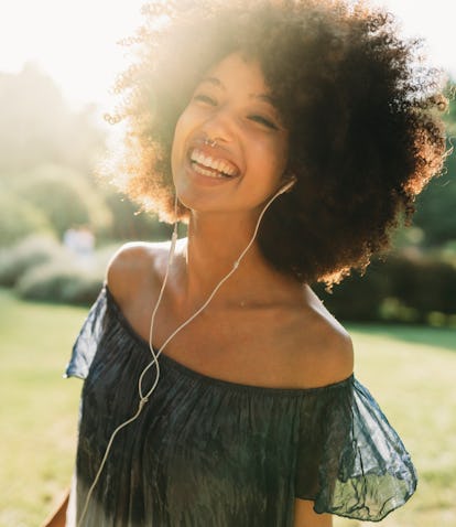 Young woman smiling thinking about how the first (1st) house in astrology is known as the house of s...