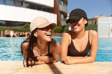two friends enjoy a pool day as the chat about their august 1, 2022 weekly horoscope 