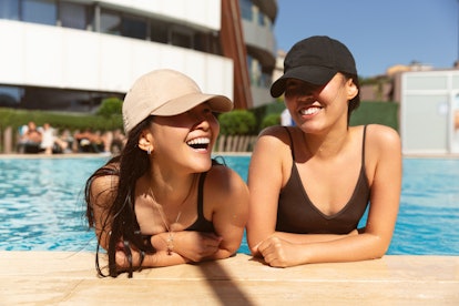 two friends enjoy a pool day as the chat about their august 1, 2022 weekly horoscope 