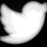 The Twitter logo is seen on various devices produced with an in camera multiple exposure. The compan...
