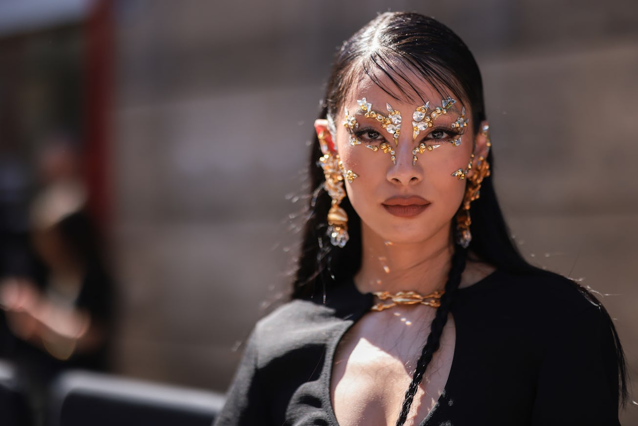 PARIS, FRANCE - JULY 04: Rina Sawayama seen wearing gold and silver rhinestones make up, gold large ...