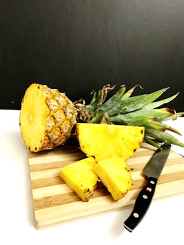 Fresh-cut pineapple on a wooden cutting board in Kampung Perlis, Malaysia
