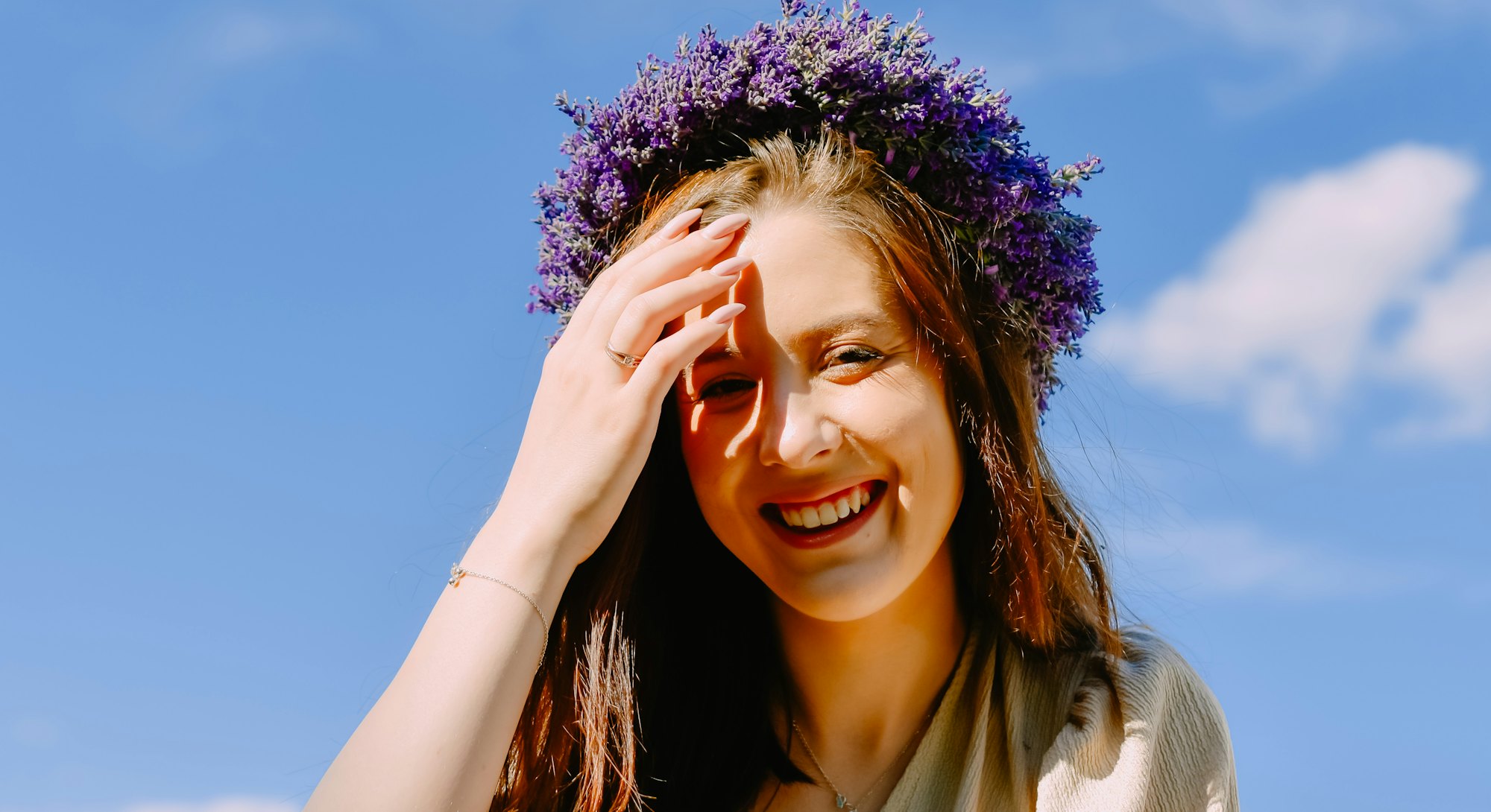 Woman in a flower crown is smiling with a clear blue sky in the background. Lion's gate portal on Au...