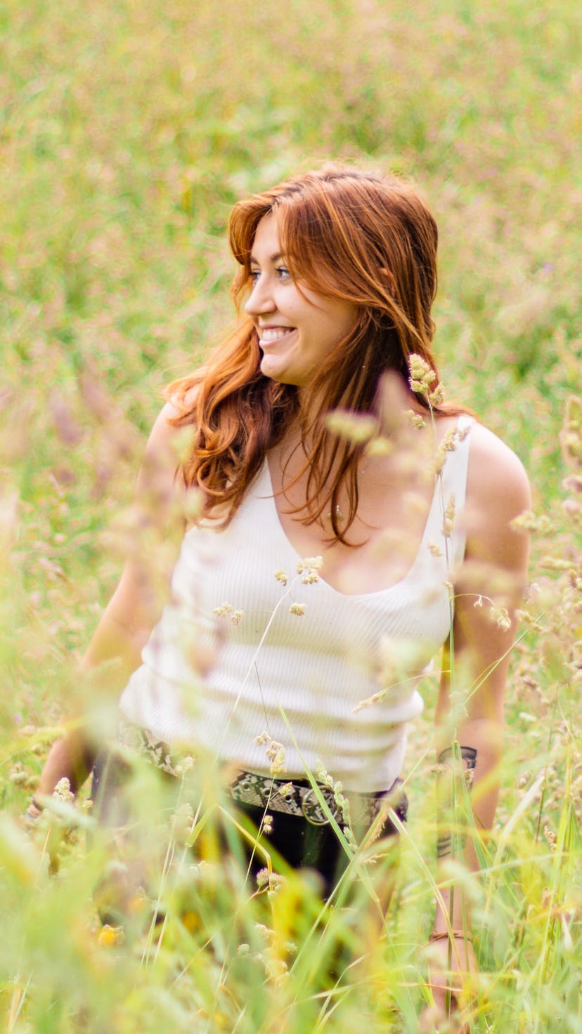Woman in a field smiling and looking out. Aries, Taurus, Cancer, Leo, Virgo, and Capricorn zodiac si...