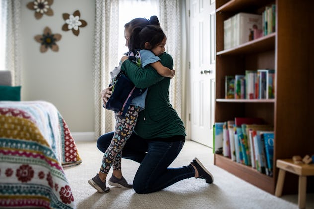 Mother embracing young daughter before school in a round up of instagram captions for back-to-school