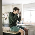 Teenage boy eating breakfast cereal in kitchen