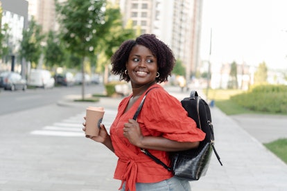 A woman enjoying coffee, which is one of the things to buy with credit card to build credit.