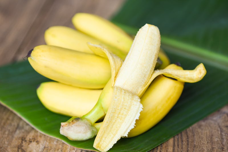 Banana peel ready to eat and ripe banana fruit on banana leaf background