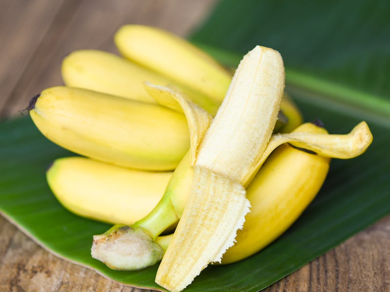 Banana peel ready to eat and ripe banana fruit on banana leaf background