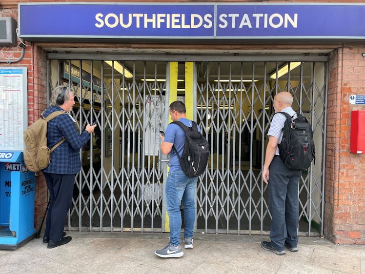 Passengers wait for the entrance gates to open at Southfields underground station in south London, t...
