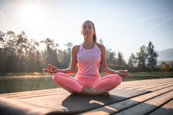Young woman practising peaceful meditation in nature. Here's your july 6 zodiac sign daily horoscope...