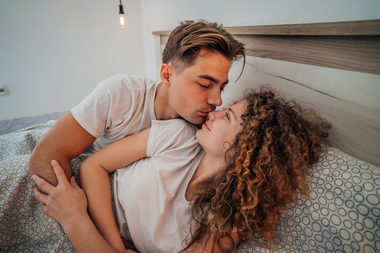 Affectionate young couple relaxing in bed and having a romantic moment