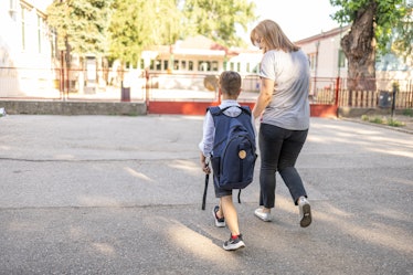 Mother walking her son to a first day in school.
