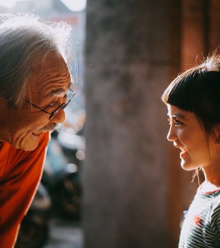 Profile view of cute young mixed race girl smiling at her grandfather, list of boundaries for grandp...