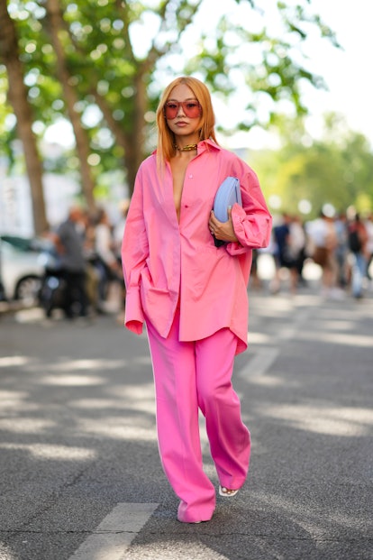 PARIS, FRANCE - JULY 03: A guest wears pink sunglasses, a gold large necklace, a pink oversized shir...