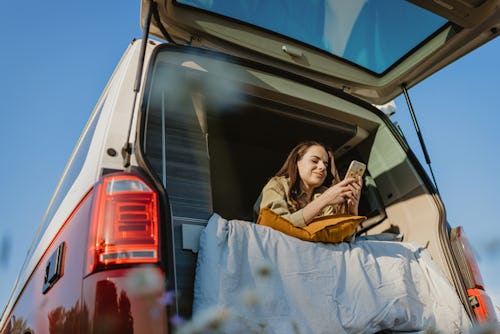 Woman with long brown hair relaxing and lying down in her van. Why are instagram DMs down? Here's ho...