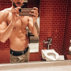 shirtless man take a selfie inside the bathroom