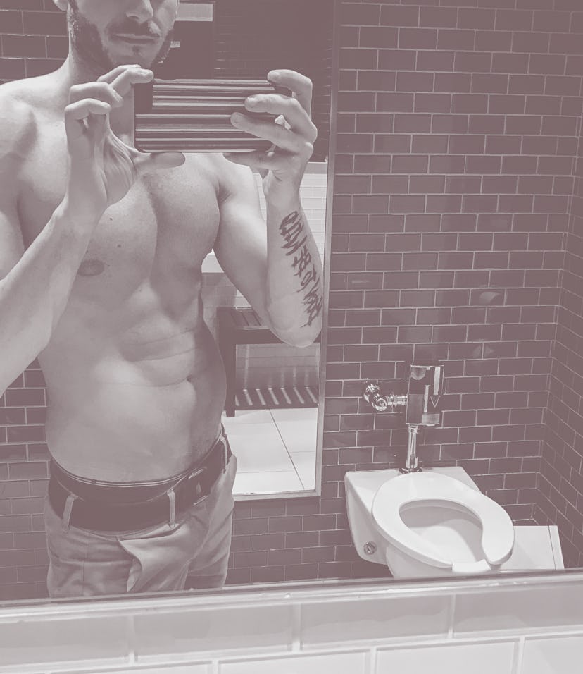 shirtless man take a selfie inside the bathroom