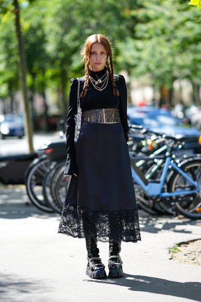 PARIS, FRANCE - JULY 03: A guest wears gold chain pendant necklaces, a black ruffled high neck / lon...