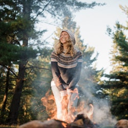 A woman leans in front of a campfire. Your guide to fire signs: everything you need to know about fi...