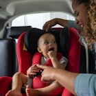 Mother putting her baby in a car seat.