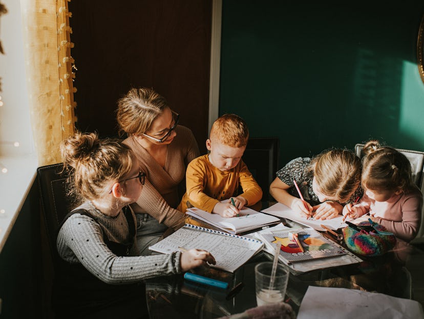 Single Mum in a home environment home schools / helps her children with homework. Recognisable scene...