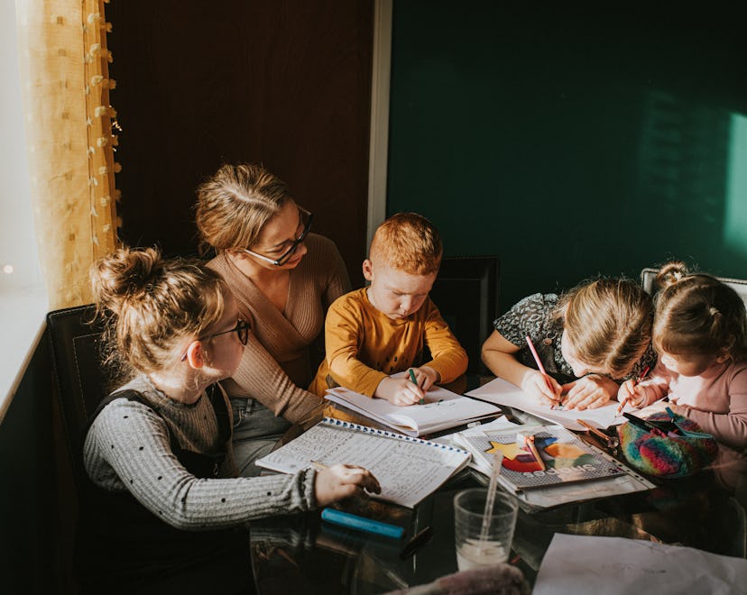 Single Mum in a home environment home schools / helps her children with homework. Recognisable scene...