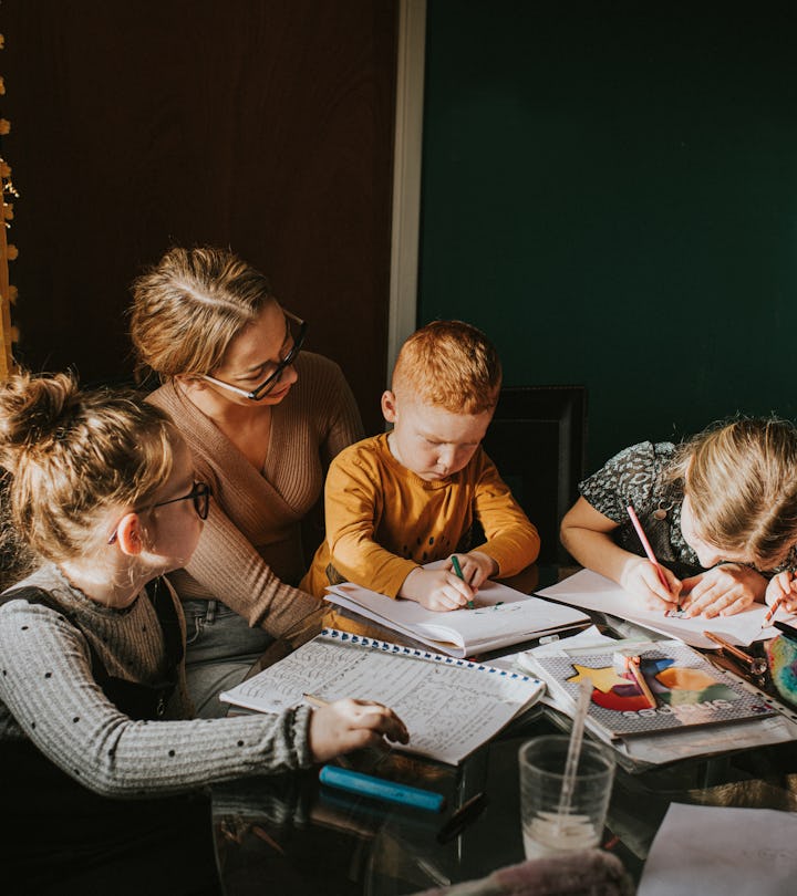 Single Mum in a home environment home schools / helps her children with homework. Recognisable scene...