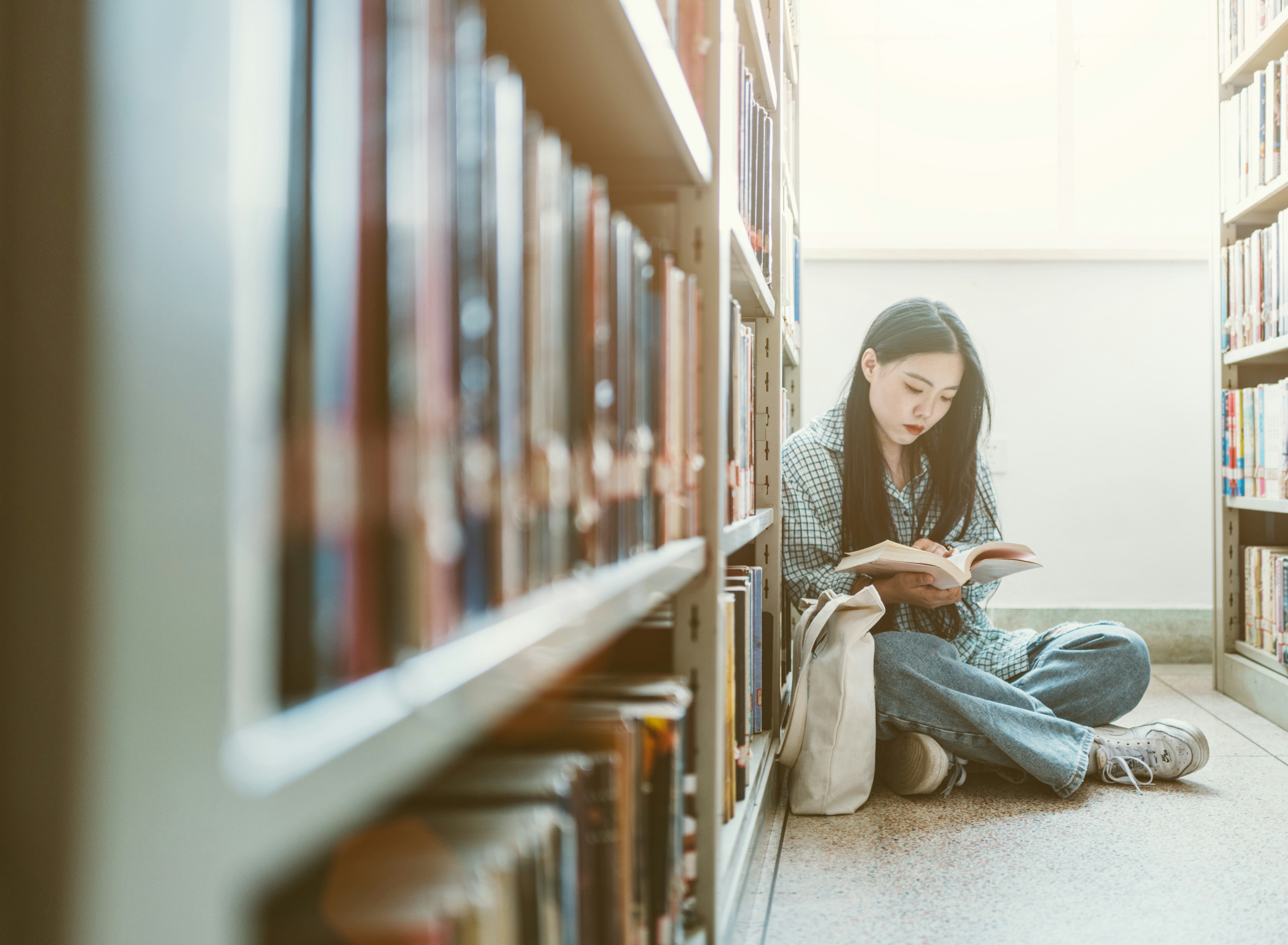 Girls choosing books and study in library