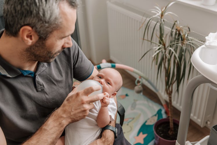 A dad bottle-feeding his newborn.