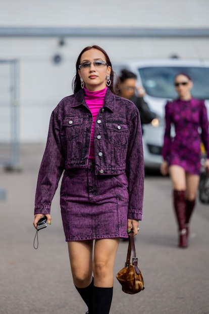 COPENHAGEN, DENMARK - AUGUST 09: A guest is seen wearing purple denim jacket, skirt, knee high black...