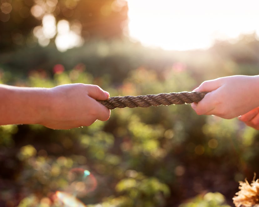 two hands holding a rope pulling against each other zodiac sign enemies who is aquarius enemy who is...
