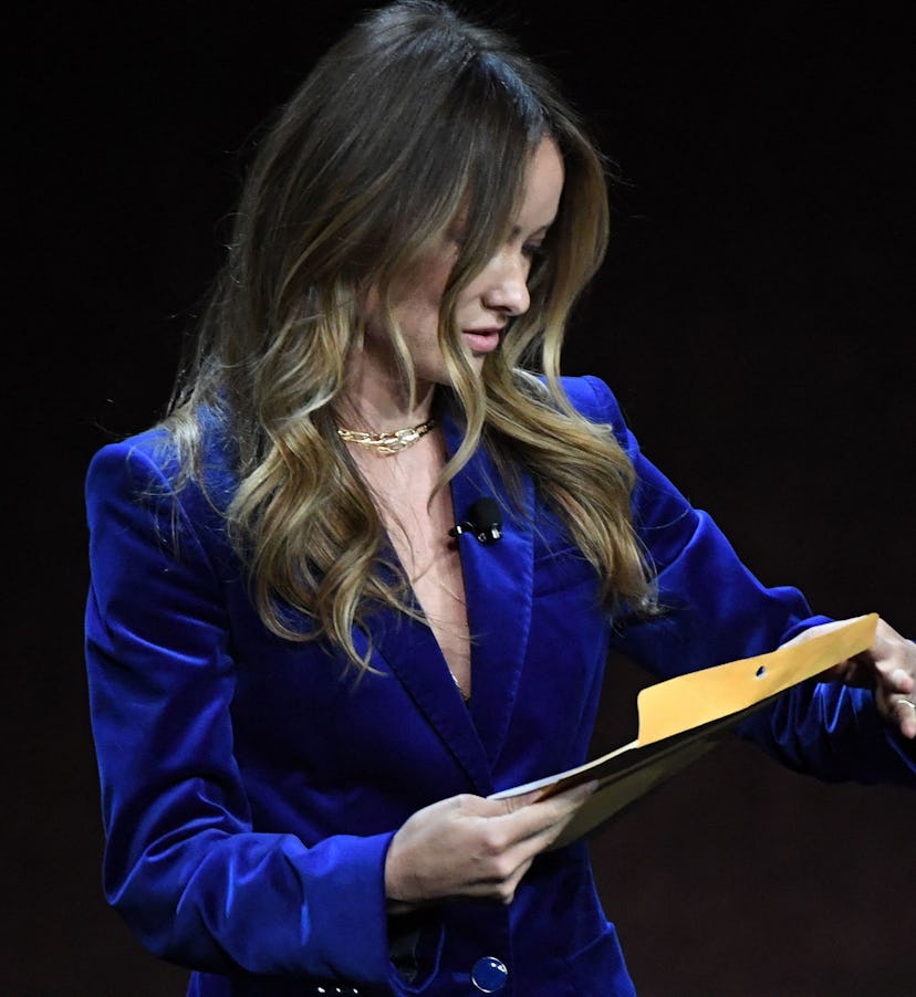US director and actress Olivia Wilde holds an envelope reading "personal and confidential" as she sp...