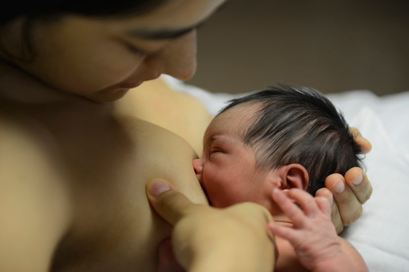 mother breastfeeding a newborn in an article about when benefits of breastfeeding diminsh