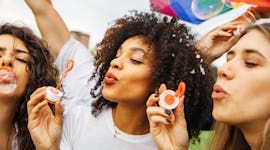 three friends blow bubbles as they chat about the astrology of the week of august 22, 2022
