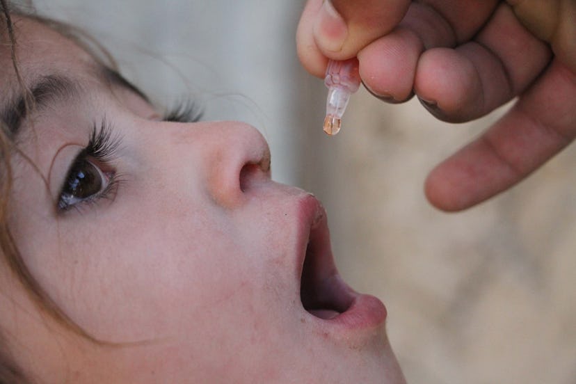 A health worker administers a polio vaccine to a child, out of Kabul Afghanistan.