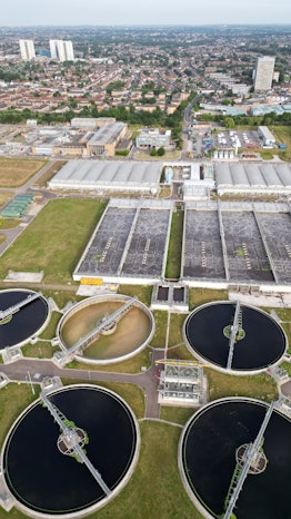 Aerial view of a wastewater treatment plant with North London housing in the background