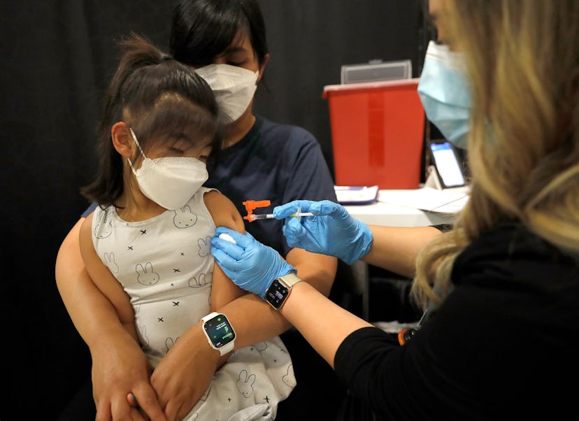 : Mary Ngim holds her daughter Emerson, of San Jose, as she gets her Covid-19 vaccination.