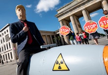30 July 2020, Berlin: An activist disguised as US President Trump drives in front of the Brandenburg...