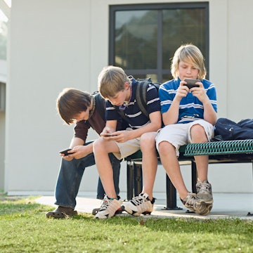 Three kids on their phones. One school's new phone policy that allows school officials to look at te...