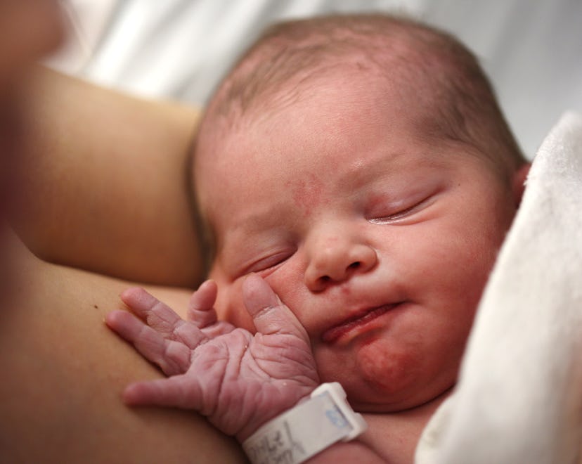 A newborn baby girl is reunited with her mother straight after birth in a hospital environment. Phot...