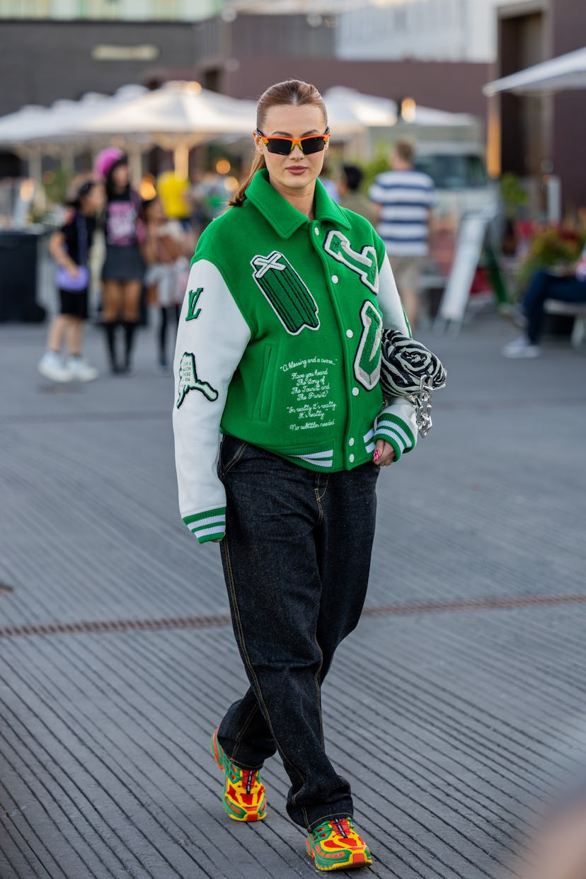 COPENHAGEN, DENMARK - AUGUST 11: A guest is seen wearing green Louis Vuitton jacket outside Ganni du...