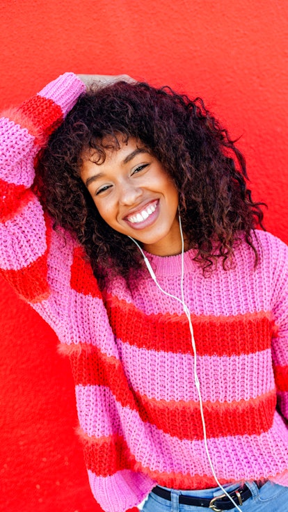 Young woman with curly hair, waiting to hear her signature scent for fall 2022.